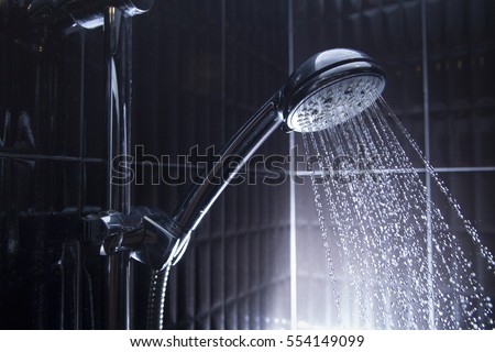 shower head in bathroom with water drops flowing