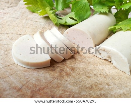Sliced Vietnamese pork roll and celery on wooden cutting board.