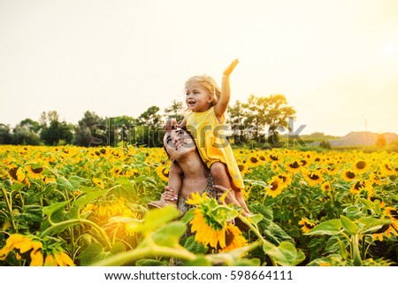 Mom and daughter in the field of sunflowers