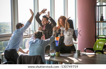 Business people giving five after dealing and signing contract or agreement with partners abroad. Colleagues showing team work in office interior.