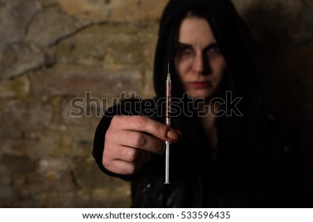 Bad woman. Addict lady with syringe using drugs. Drug addict woman holding syringe with drugs in front of her.