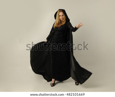 https://thumb7.shutterstock.com/display_pic_with_logo/3644120/482101669/stock-photo-full-length-portrait-of-a-pretty-blonde-lady-wearing-a-gothic-black-dress-and-hooded-cloak-482101669.jpg