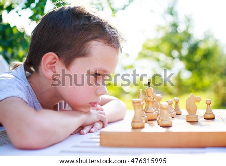 young chess player outdoors. the boy concentrating on the game of chess. view profile