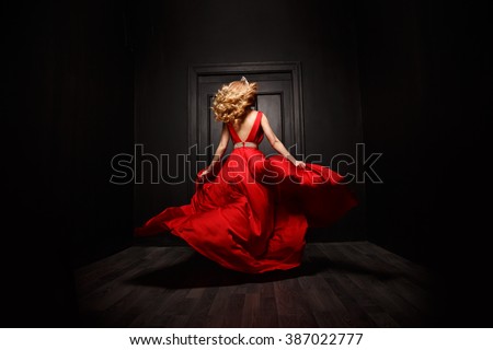 stock photo elegant and sexy woman in the red evening fluttering dress is capture in move running away from 387022777