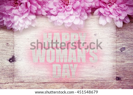 pink flowers on wooden with word Happy Woman's Day