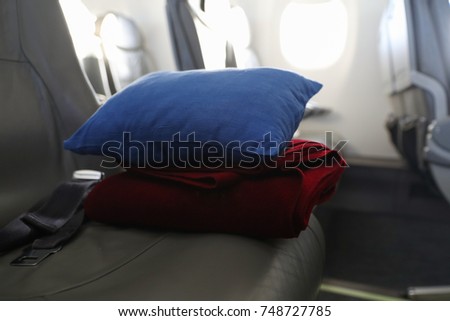 Pillow and blanket lying on the seat in the plane