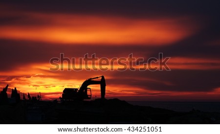 LY SON ISLAND, VIETNAM - JUNE 2016 : Beautiful sunset over boats on the sea of Ly Son island, Quang Ngai province, Vietnam. Flag and crane waving in the red sky. Revolution abstract. Sihouette.