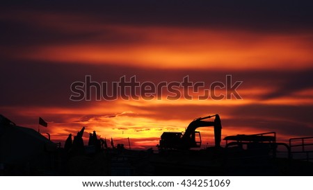 LY SON ISLAND, VIETNAM - JUNE 2016 : Beautiful sunset over boats on the sea of Ly Son island, Quang Ngai province, Vietnam. Flag and crane waving in the red sky. Revolution abstract. Sihouette.