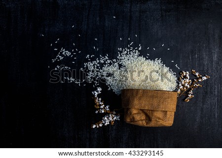 rice in sack,white rice in burlap sack with rice grain on the black wood