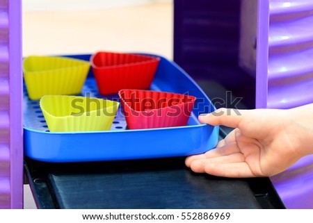 Small child plays. Children's play kitchen. Child gets out of a toy oven molds with imaginary cupcakes. How to play bake cupcakes. Kid and imagination