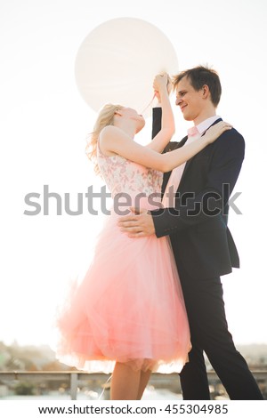 https://thumb7.shutterstock.com/display_pic_with_logo/3823586/455304985/stock-photo-young-couple-in-love-posing-on-roof-with-perfect-city-view-holding-hands-and-hugging-beautiful-455304985.jpg
