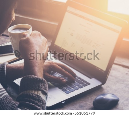 Cropped image of a young man working on his laptop in a coffee shop, rear view of business man hands busy using laptop at office desk,young male student typing on computer sitting at wooden table