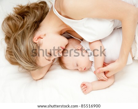 Young mother and her baby, sleeping in bed