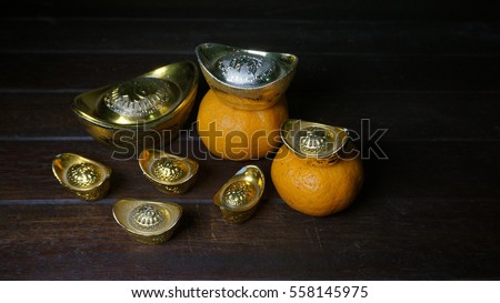 Chinese Gold Ingots And Tangerine On A Rustic Wooden Background Text Means Lucky Chinese Gold Ingots And Tangerine On A Rustic Wooden Background Text Means Lucky