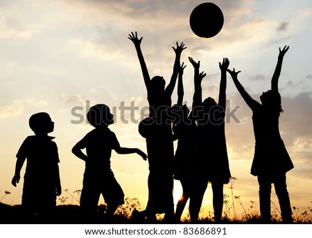 Silhouette, group of happy children playing on meadow, sunset, summertime