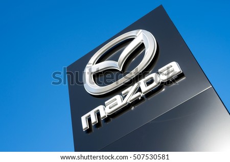 GUMMERSBACH, GERMANY - October 30, 2016: Mazda dealership sign against blue sky. Mazda is a Japanese automaker and produces over 1 million vehicles per year.