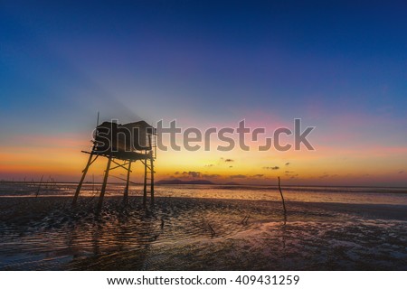 CAN GIO, HO CHI MINH CITY, VIET NAM - JAN 10, 2016: sunrise on the sea with shadow rudimentary leaves home on the Can Gio sea.
