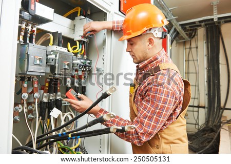 young adult electrician builder engineer worker in front of fuse switch board
