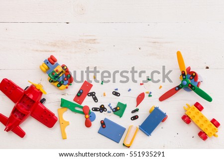 Top view on colorful toy bricks on a white wooden background. Toys in the table