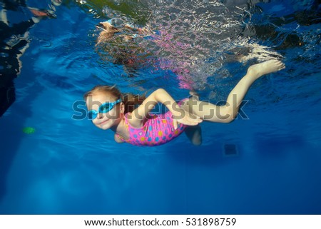 happy little baby swims underwater in the pool looking at the camera and smiling portrait - Kids Swimming Underwater happy little baby swims underwater in the pool looking at the camera and smiling portrait - Kids Swimming Underwater