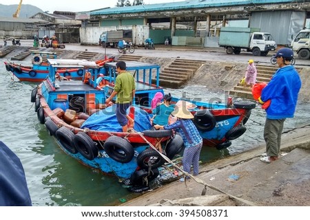 Editorial: Quy Nhon, Vietnam, 18th January 2015. Passengers boarding a small wooden boats that that brings them to a small peninsula.
