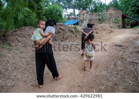 Vinh Phuc, Vietnam, May 12, 2016 a grandmother, carried him on his back, on his way home, rural Vinh Phuc, Vietnam