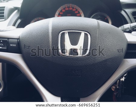 KUALA LUMPUR, January 13, 2016 : View of a hand holding HONDA steering and meter. Focus on HONDA logo. A crop close up steering wheels