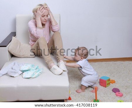 woman sits with her child, postpartum depression