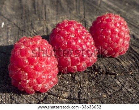 Delicious juicy raspberries in a wooden bowl Top view