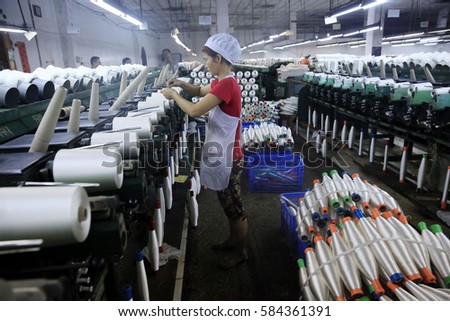 JIUJIANG CHINA-Oct9, 2013:Jiangxi,female workers in Jin Yuan chemical fiber products Co., Ltd. factory workshop. Chemical fiber products will be exported to Europe, America and Southeast asia.