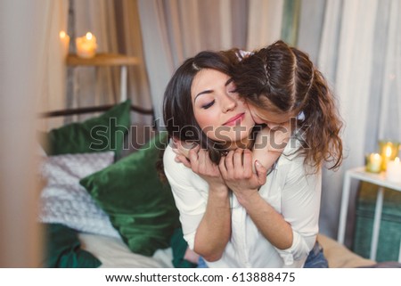 Mom and daughter are hugging in bed. Close-up.