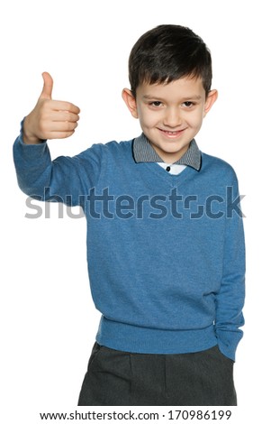 Young boy in blue pullover holds his thumb up on the white background