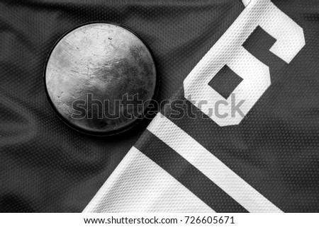 Dark black and white still life puck on a jersey as a winter sport background Dark black and white still life puck on a jersey as a winter sport background