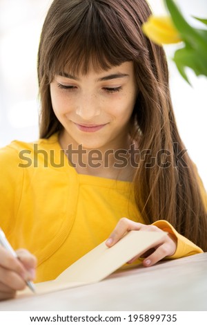 beautiful girl writes greeting card