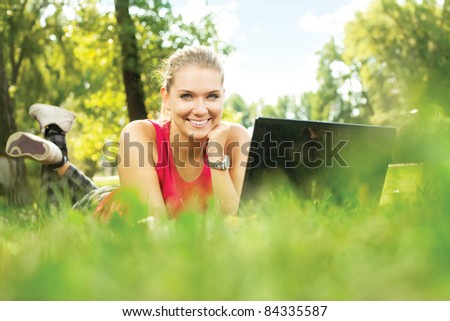 stock-photo-smiling-pretty-girl-lying-down-on-the-green-grass-typing-laptop-computer-84335587.jpg