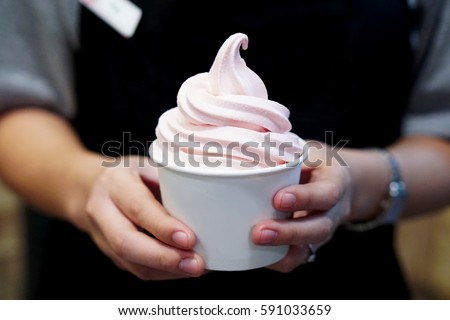 Closeup of woman's hands holding cup with organic frozen yogurt Ice cream served in a plastic takeaway, Healthy eating concept.