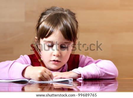 Lovely little girl learning to write