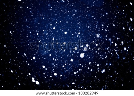 Falling snow background - snowflakes over night dark sky