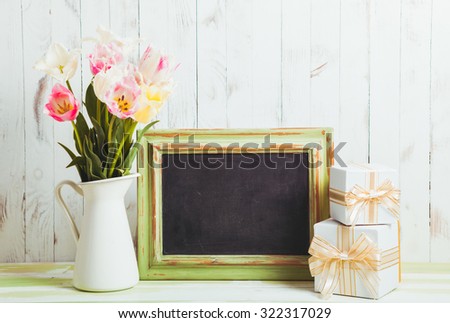 Pink tulips in jug and green wooden chalkboard. Teacher's day concept