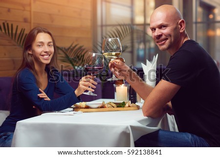 https://thumb7.shutterstock.com/display_pic_with_logo/4574653/592138841/stock-photo-a-young-man-and-woman-in-the-restaurant-having-dinner-looking-at-camera-and-smiling-while-clink-592138841.jpg
