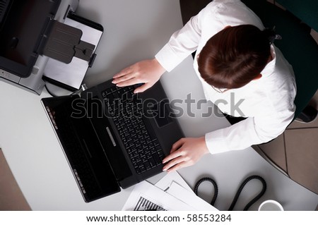 Young business woman working on a laptop at his desk in the office