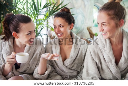 Three young happy women drinking tea at spa resort