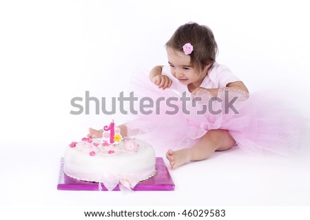 Baby girl and her first birthday cake - stock photo