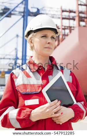 Female engineer holding tablet computer in shipping yard