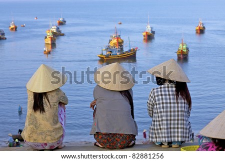 MUI NE, VIETNAM - APRIL 16: Unidentified women await returning fishing boats in Mui Ne, Vietnam at sunrise on April 16, 2011. Vietnam seafood export is expected to reach $6.5bl USD by 2015.