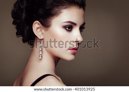 Fashion portrait of young beautiful woman with jewelry. Brunette girl. Perfect make-up. Beauty style woman with diamond accessories