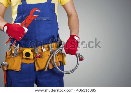 plumber with tool belt isolated on gray with copy space
