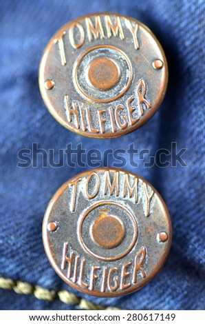 CIRCA JUNE 2014 KWIDZYN: Closeup of Tommy Hilfiger button on blue jeans. Tommy Hilfiger is lifestyle brand founded by American fashion designer Thomas Jacob Hilfiger (born in 1951).