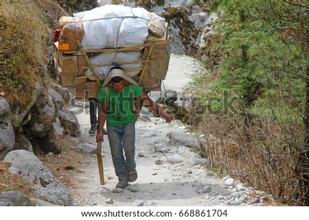 stock-photo-everest-camp-national-park-nepal-april-the-young-sherpa-porter-carrying-heavy-sacks-668861704.jpg