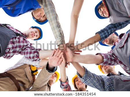 Large group of construction worker stacking hands. Isolated on white